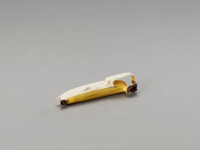Lot 107 - A STAINED IVORY ‘TROMPE-L’OEIL’ OKIMONO OF A BANANA