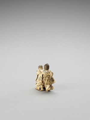 Lot 154 - AN IVORY OKIMONO OF A MAN AND TWO CHILDREN AT PLAY