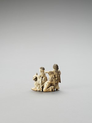 Lot 154 - AN IVORY OKIMONO OF A MAN AND TWO CHILDREN AT PLAY