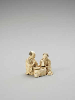 Lot 152 - AN IVORY OKIMONO OF A COUPLE EATING