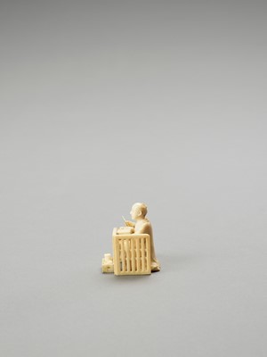 Lot 142 - AN IVORY OKIMONO OF A MAN WRITING IN A BOOK