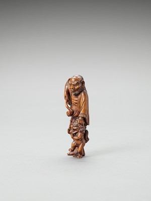 Lot 314 - A WOOD NETSUKE OF A SENNIN WITH ONI