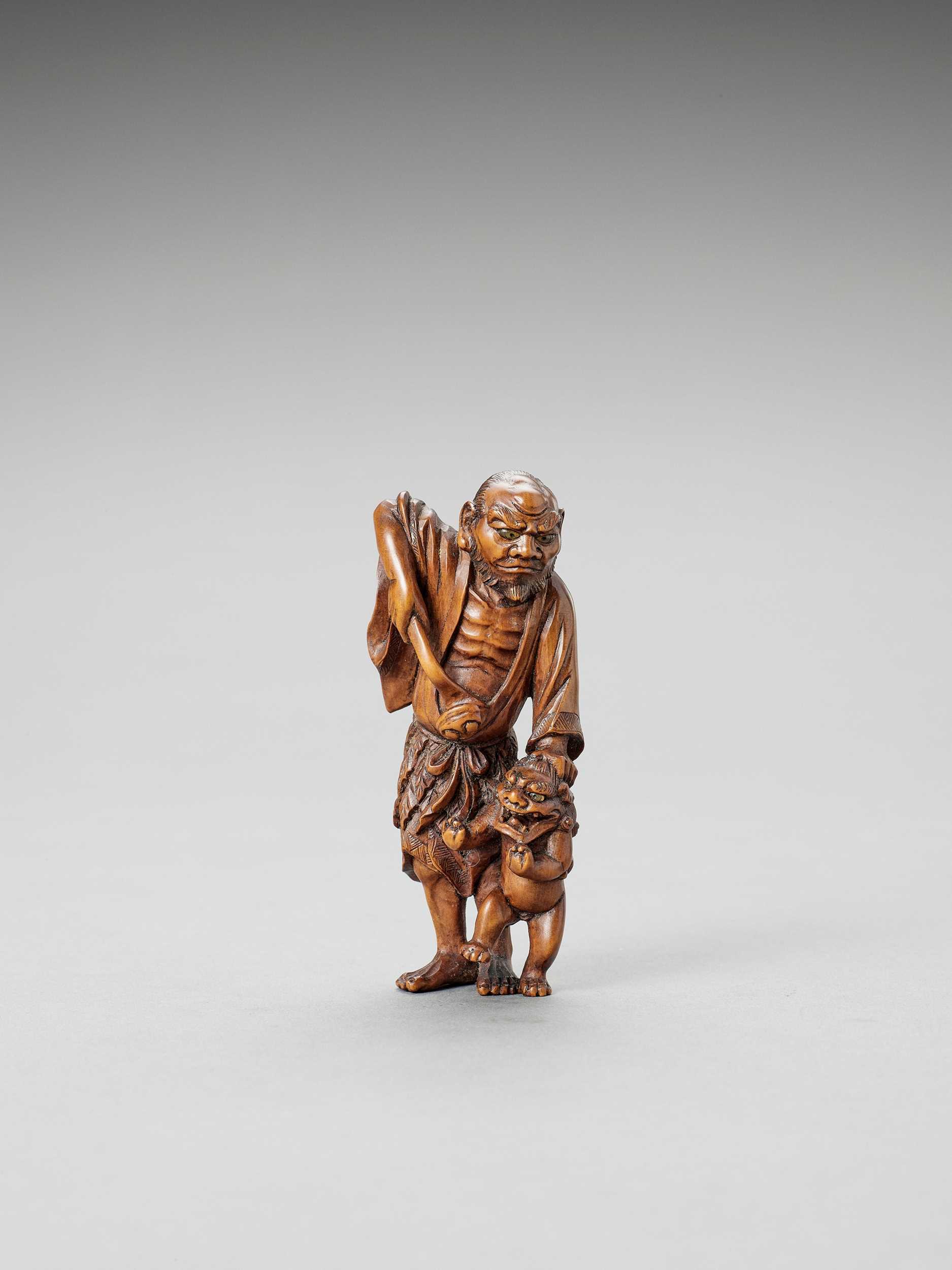 Lot 314 - A WOOD NETSUKE OF A SENNIN WITH ONI