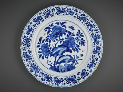 Lot 321 - A LARGE BLUE AND WHITE ‘PRUNUS AND BUTTERFLY’ LOBED DISH, KANGXI MARK AND PERIOD