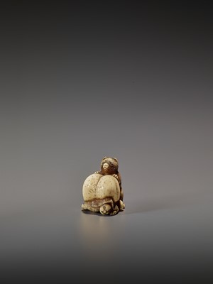 Lot 265 - SHUNGETSU: IVORY NETSUKE OF A TANUKI SUFFOCATING A HUNTER WITH HIS SCROTUM