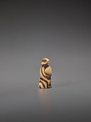 Lot 264 - A STAG ANTLER NETSUKE OF A MONKEY WITH CHESTNUT