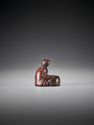 Lot 417 - AN EARLY LACQUERED WOOD NETSUKE OF A MAN WITH HIBACHI
