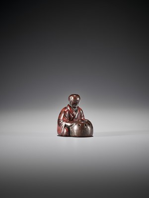 Lot 417 - AN EARLY LACQUERED WOOD NETSUKE OF A MAN WITH HIBACHI