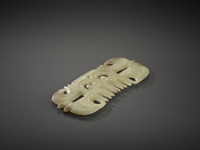 Lot 153 - A LIGHT YELLOW JADE ‘TOOTHED’ ORNAMENT WITH MASK MOTIF