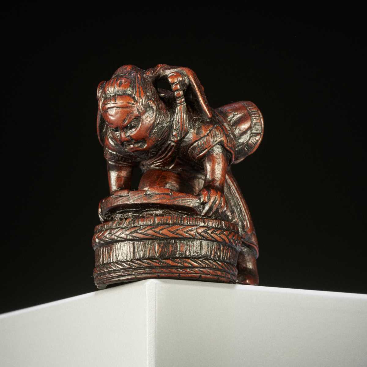 Lot 397 - A WOOD NETSUKE OF SHOKI CAPTURING ONI