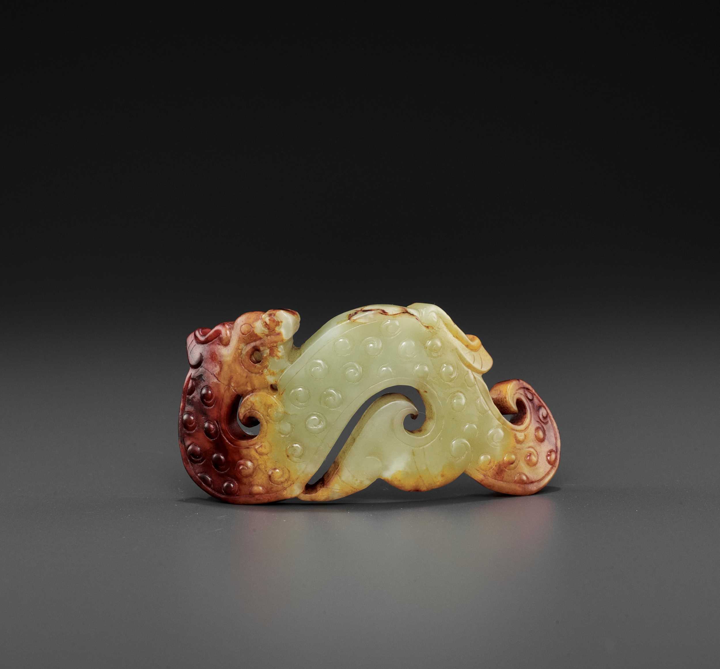 Lot 76 - A YELLOW AND RUSSET JADE ‘ARCHAISTIC’ WRIST ORNAMENT, SONG DYNASTY