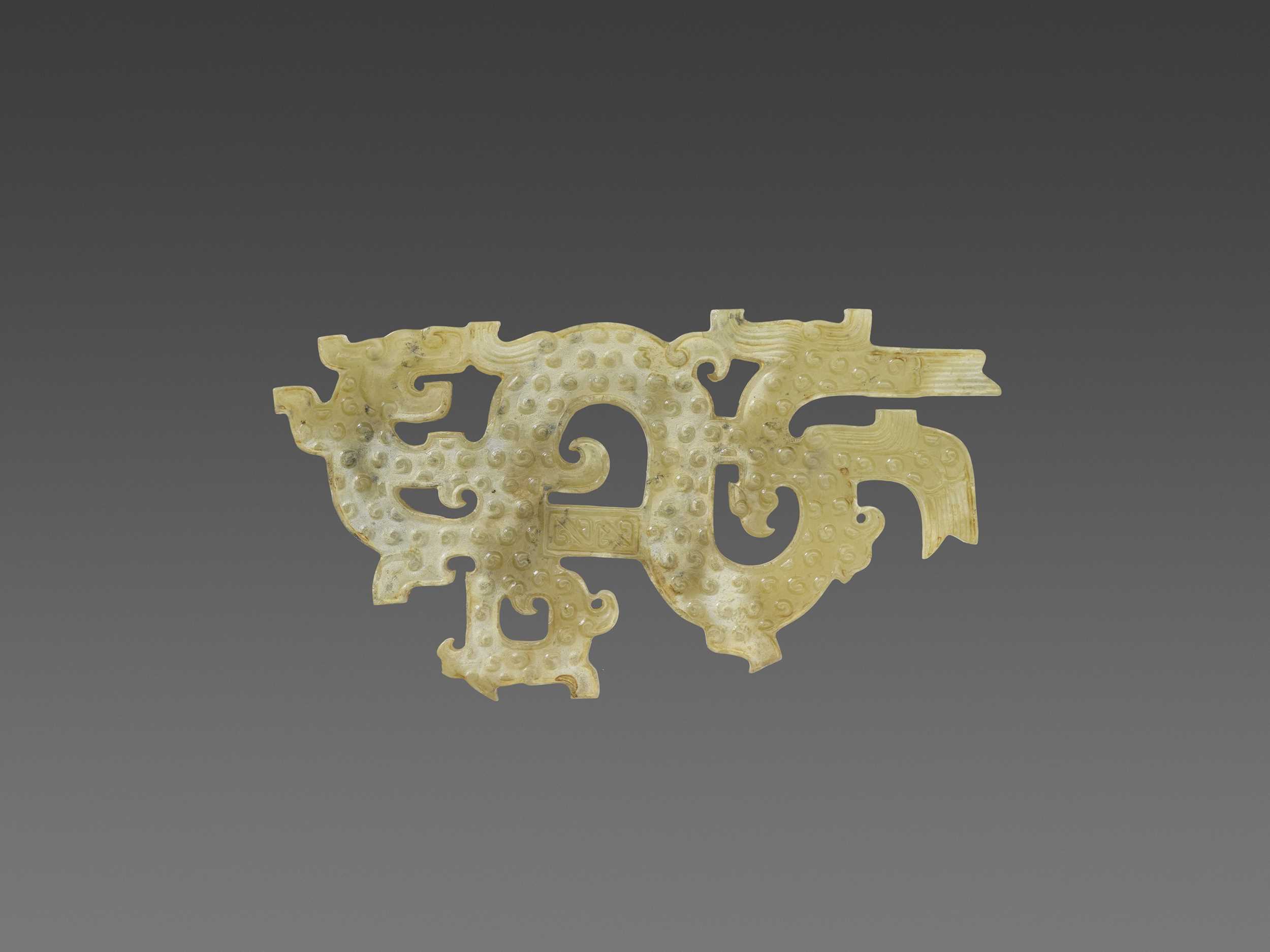Lot 89 - AN EASTERN ZHOU SINUOUS DRAGON CARVING WITH PHOENIX HEADS
