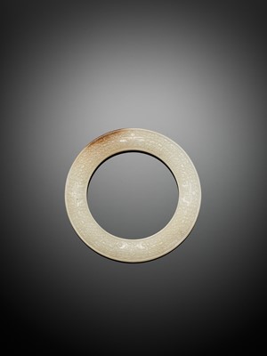 A WHITE JADE RING WITH INCISED CURLS AND TAOTIE MASKS, EASTERN ZHOU