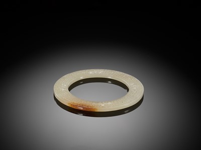 A WHITE JADE RING WITH INCISED CURLS AND TAOTIE MASKS, EASTERN ZHOU