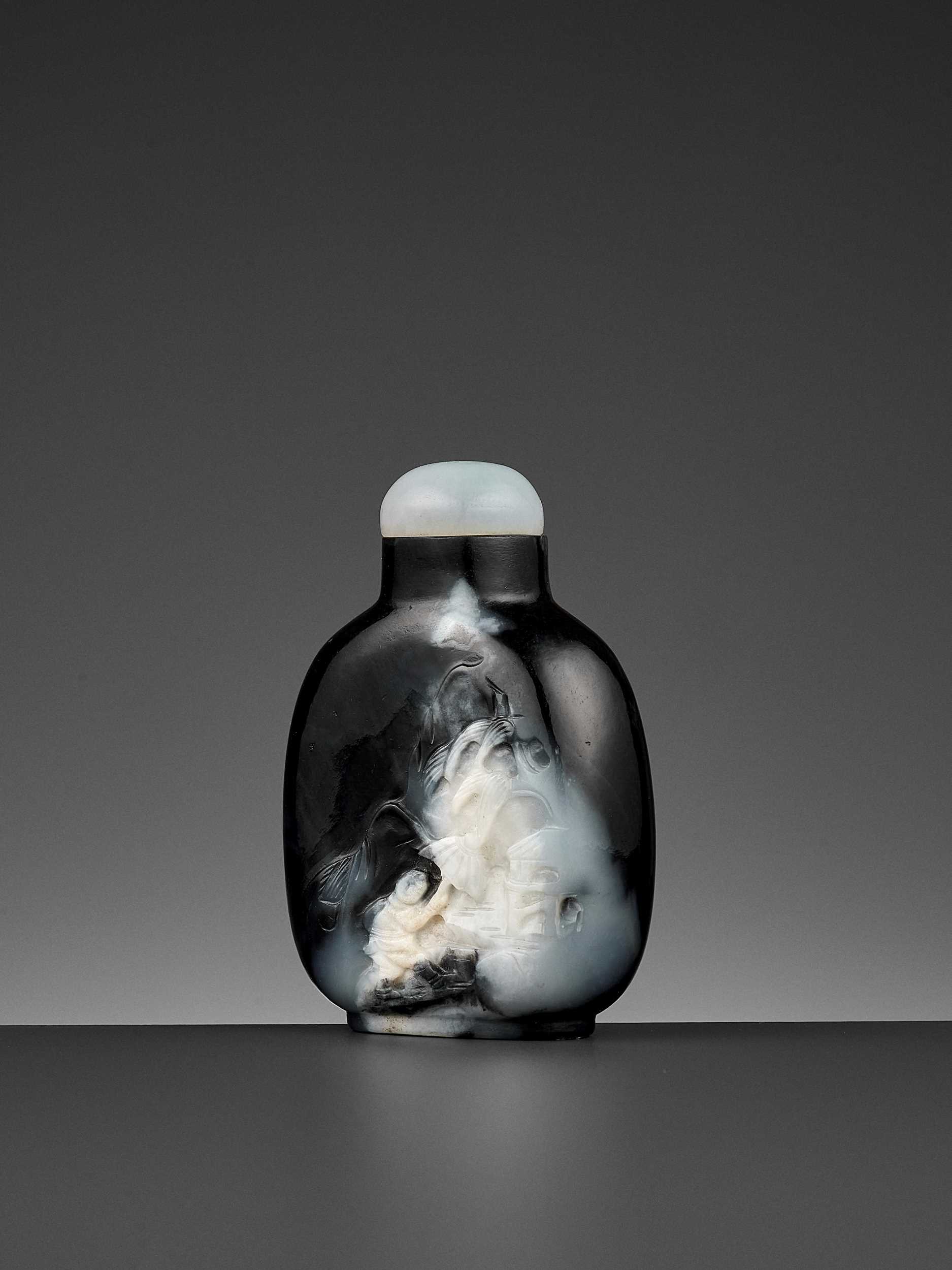 Lot 349 - A BLACK AND WHITE JADE ‘SEEKING SHELTER’ SNUFF BOTTLE, ‘MASTER OF THE ROCKS’ SCHOOL, QING DYNASTY