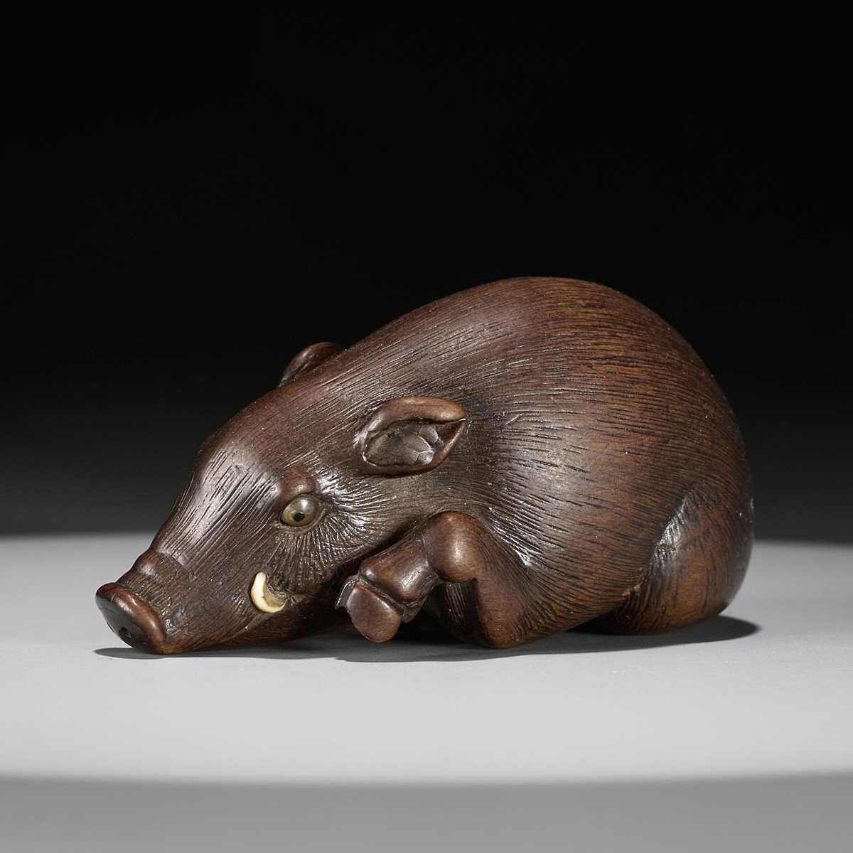 Lot 144 - RANJO: A SUPERB AND RARE WOOD NETSUKE OF A RECUMBENT BOAR