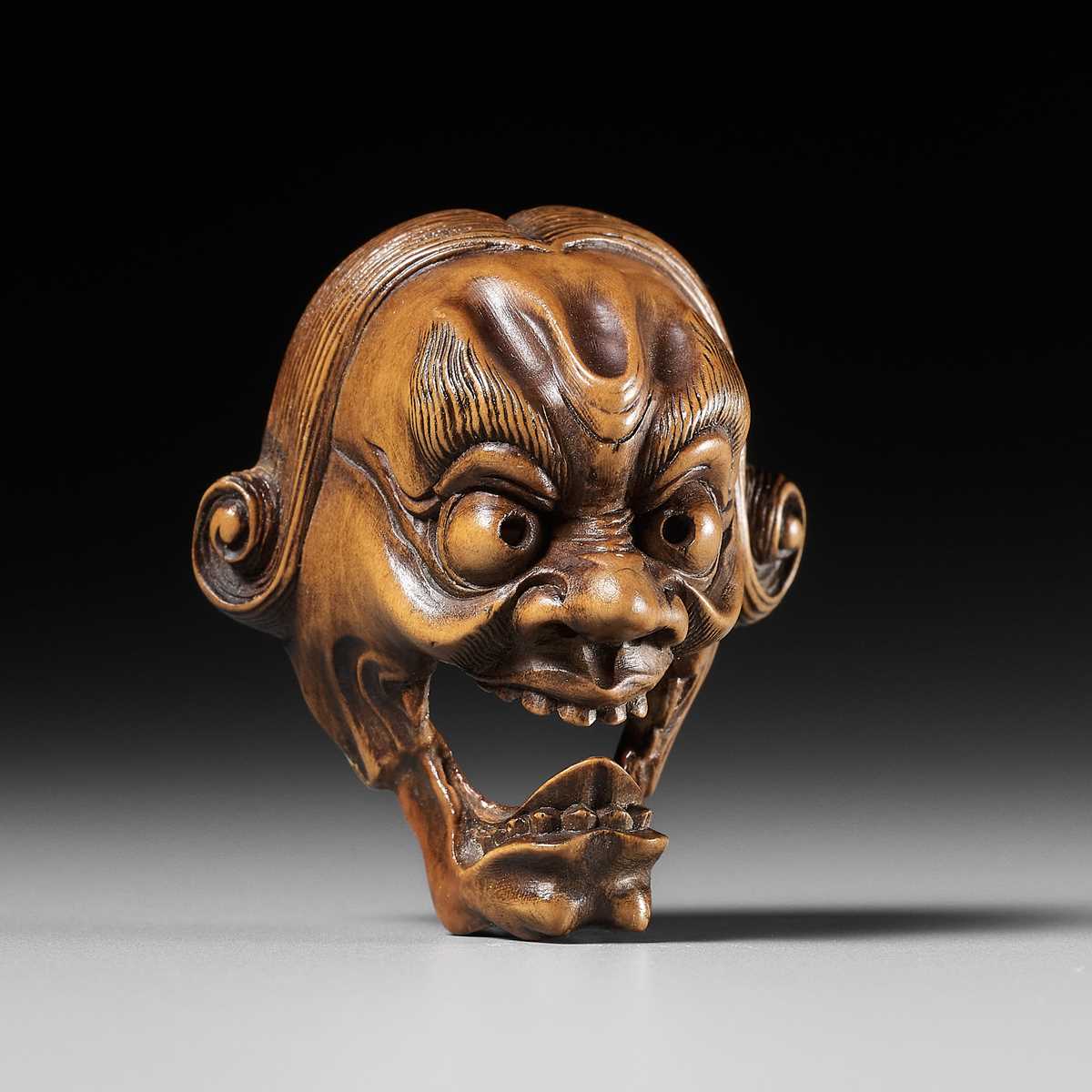 Lot 251 - A PALE BOXWOOD KYOGEN MASK NETSUKE OF A
