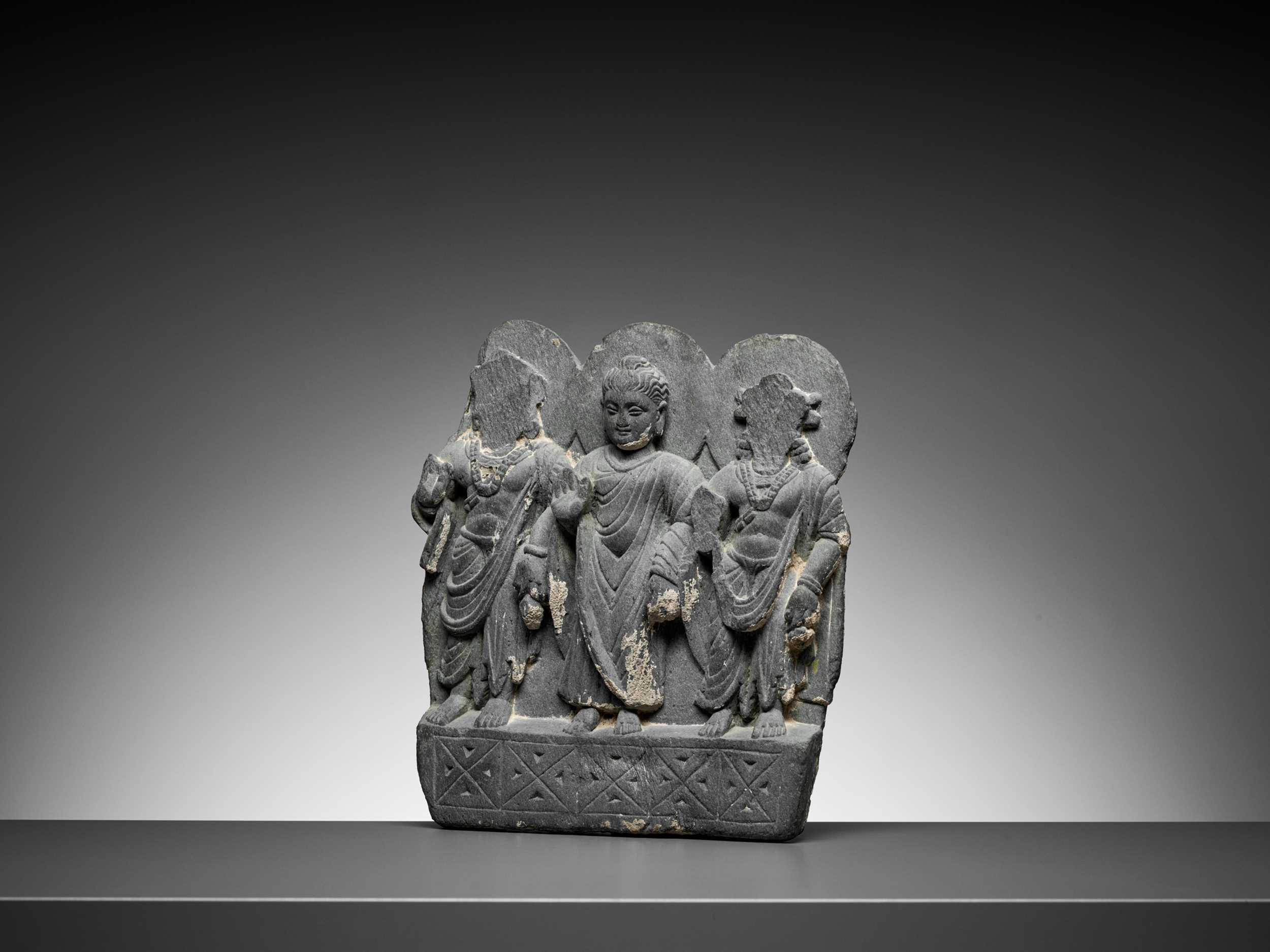 Lot 544 - A GRAY SCHIST RELIEF OF BUDDHA AND TWO