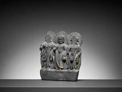 Lot 544 - A GRAY SCHIST RELIEF OF BUDDHA AND TWO BODHISATTVAS, GANDHARA