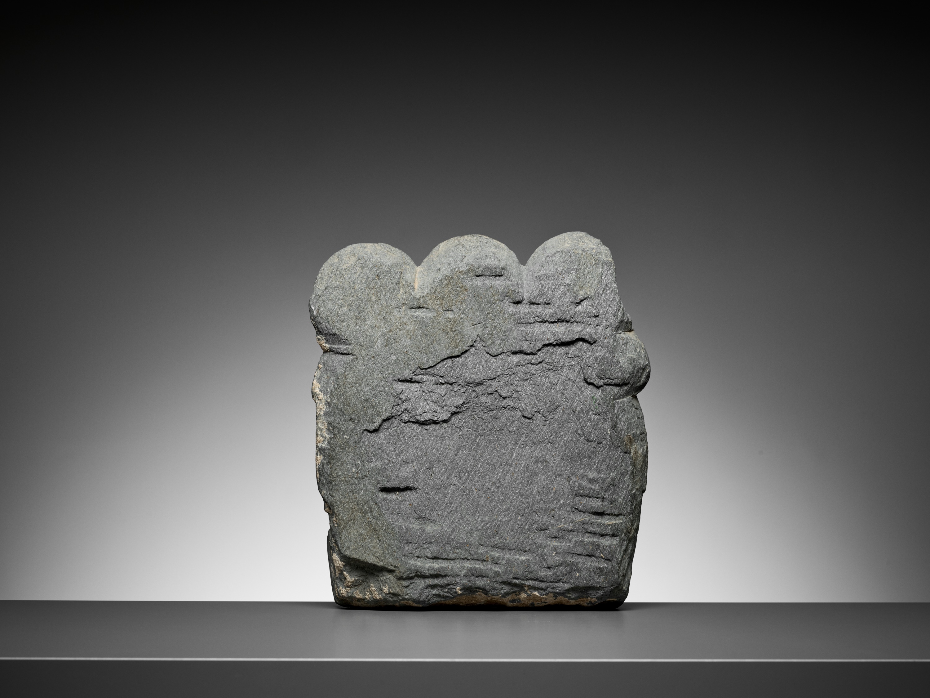 Lot 544 - A GRAY SCHIST RELIEF OF BUDDHA AND TWO