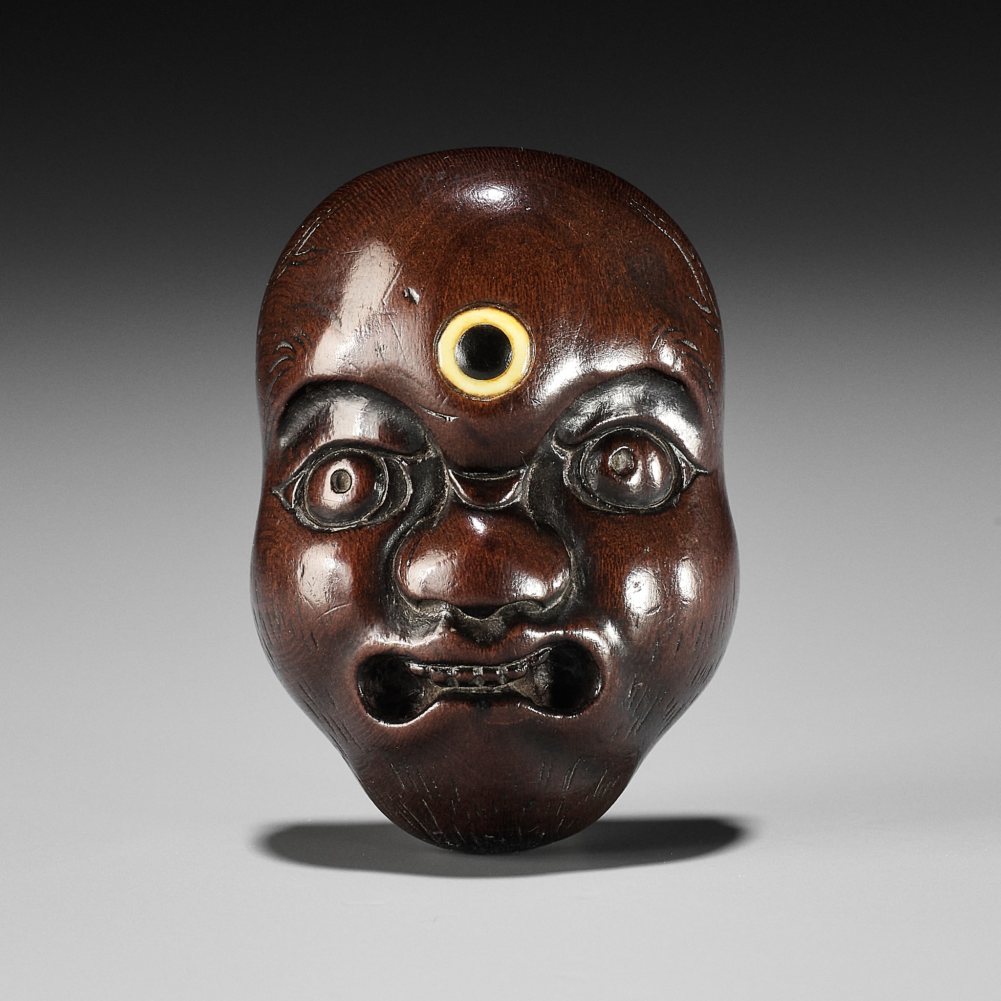 A RARE WOOD MASK NETSUKE OF THE BAKEMONO MITSUME KOZO