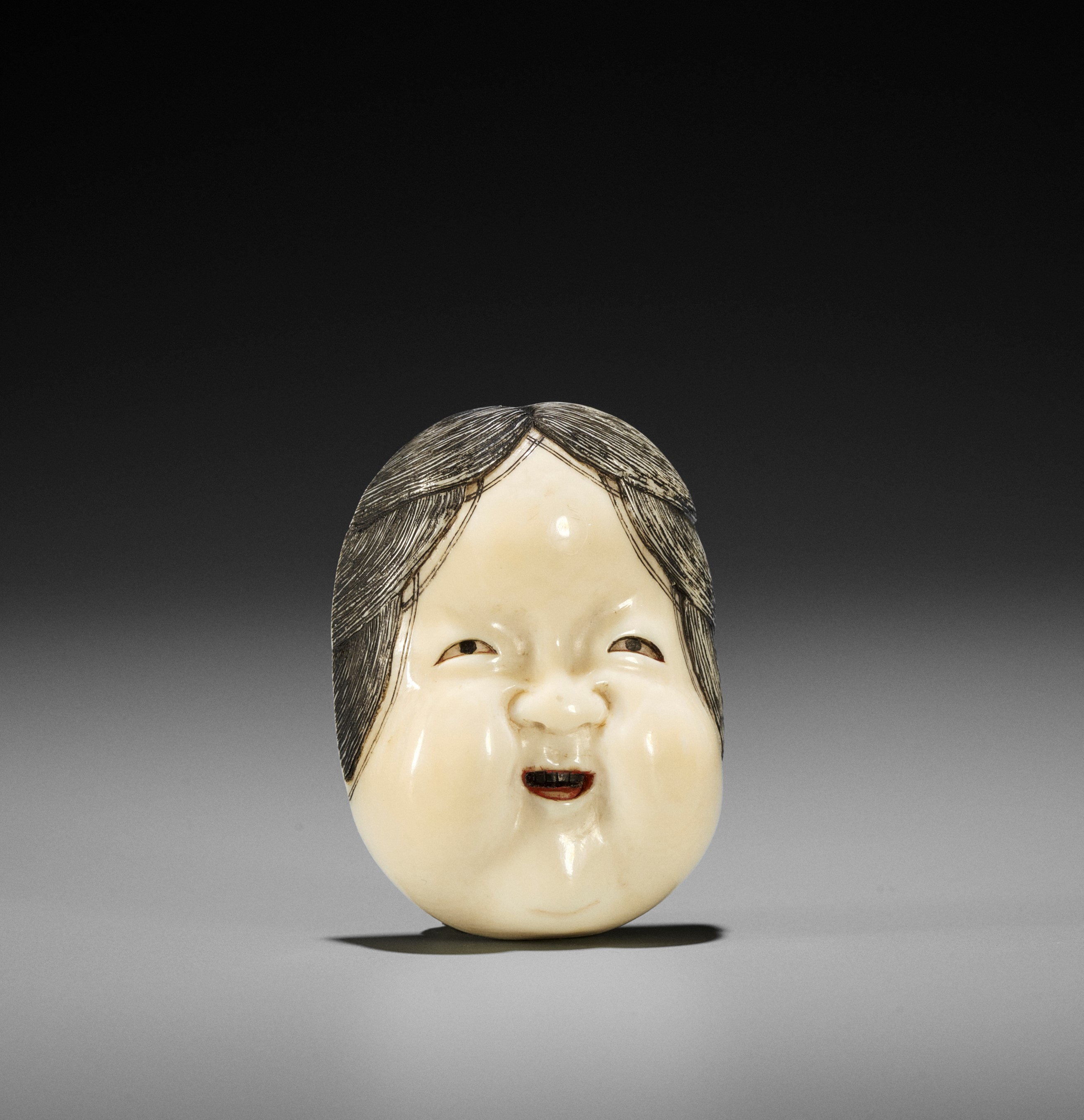 Lot 583 - KOGYOKU: A FINE IVORY MASK NETSUKE OF OKAME