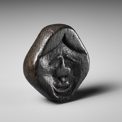 Lot 256 - AN UNUSUAL KIRI (PAULOWNIA) WOOD SHUNGA MASK NETSUKE OF FUKUWARAI TYPE