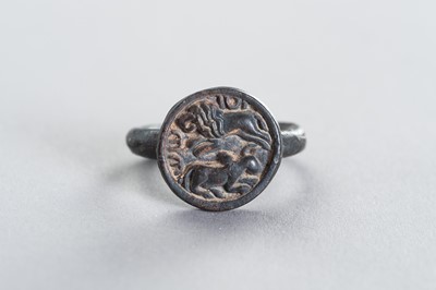 Lot 1373 - A BRONZE INTAGLIO RING WITH A HUNTING LION