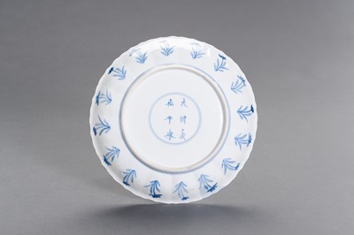 Lot 329 - A FINE BLUE AND WHITE PORCELAIN ‘HUNTING PARTY’ BARBED-RIM DISH, KANGXI