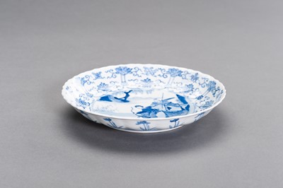 Lot 329 - A FINE BLUE AND WHITE PORCELAIN ‘HUNTING PARTY’ BARBED-RIM DISH, KANGXI