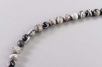 Lot 223 - A LOT OF SIXTY SULEMANI BANDED ONYX BEADS