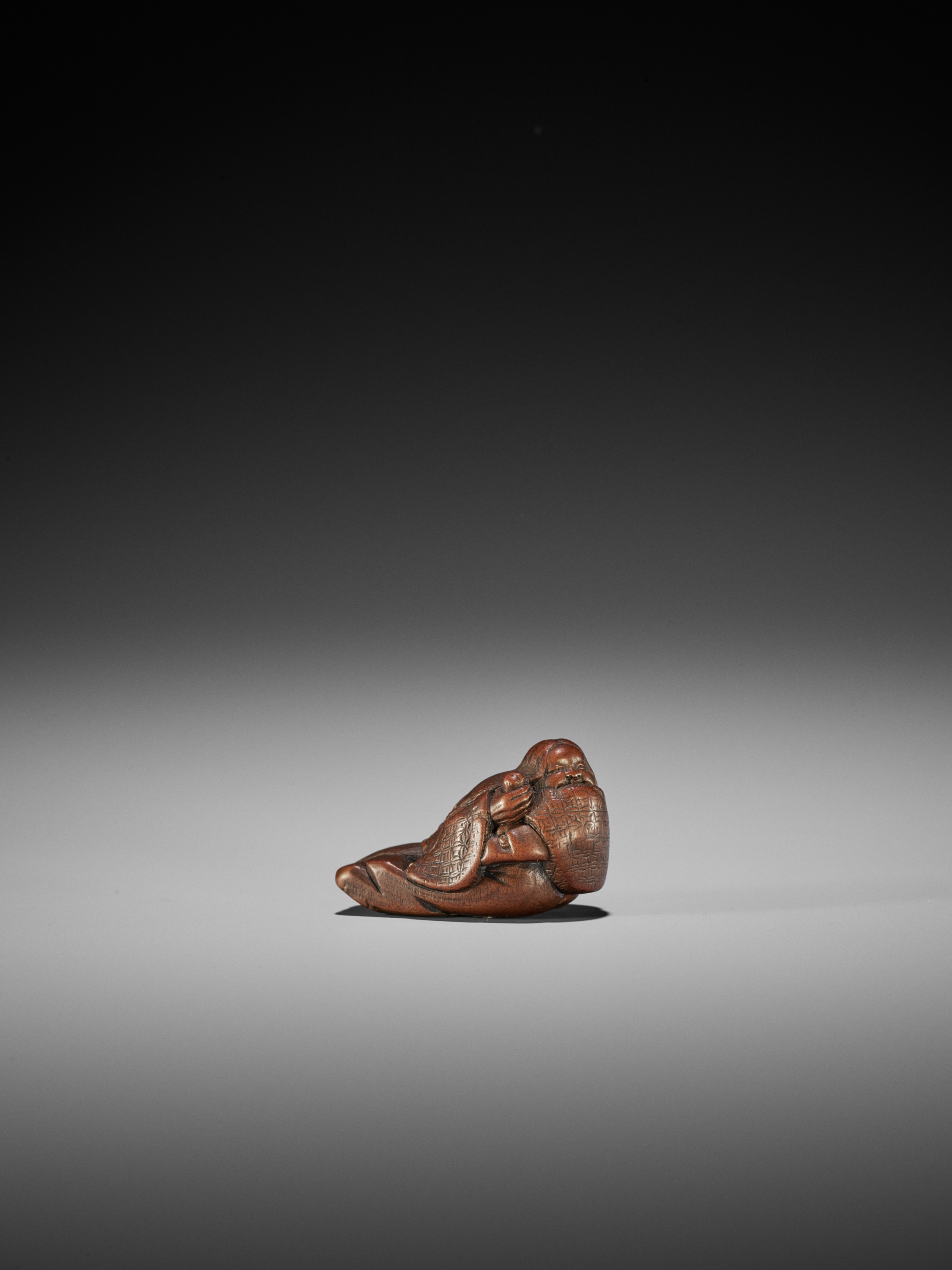 Lot 95 - ICHIMIN: A FINE WOOD SHUNGA NETSUKE OF OKAME