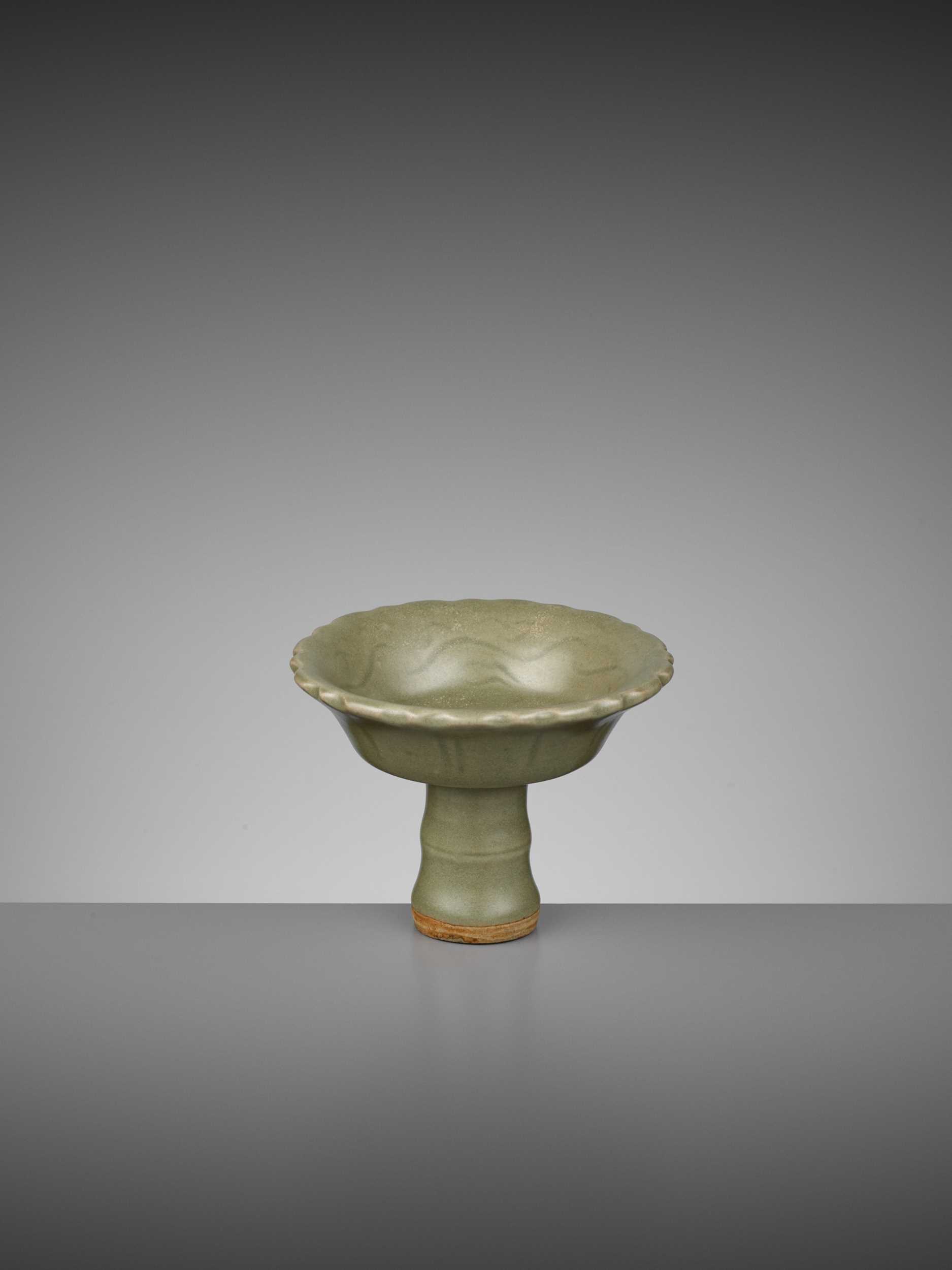 Lot 721 - A LONGQUAN CELADON ‘BAMBOO’ BARBED-RIM STEM CUP, YUAN TO EARLY MING