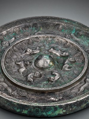 Lot 344 - A SILVERED BRONZE ‘LION AND GRAPEVINE’ MIRROR, TANG DYNASTY