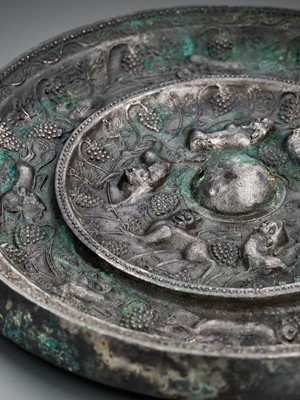 Lot 344 - A SILVERED BRONZE ‘LION AND GRAPEVINE’ MIRROR, TANG DYNASTY