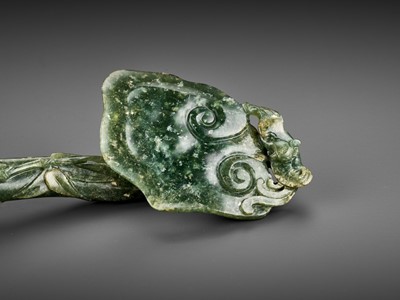 Lot 107 - A SPINACH-GREEN JADE RUYI SCEPTER WITH MATCHING ‘SANDUO’ STAND, QING DYNASTY