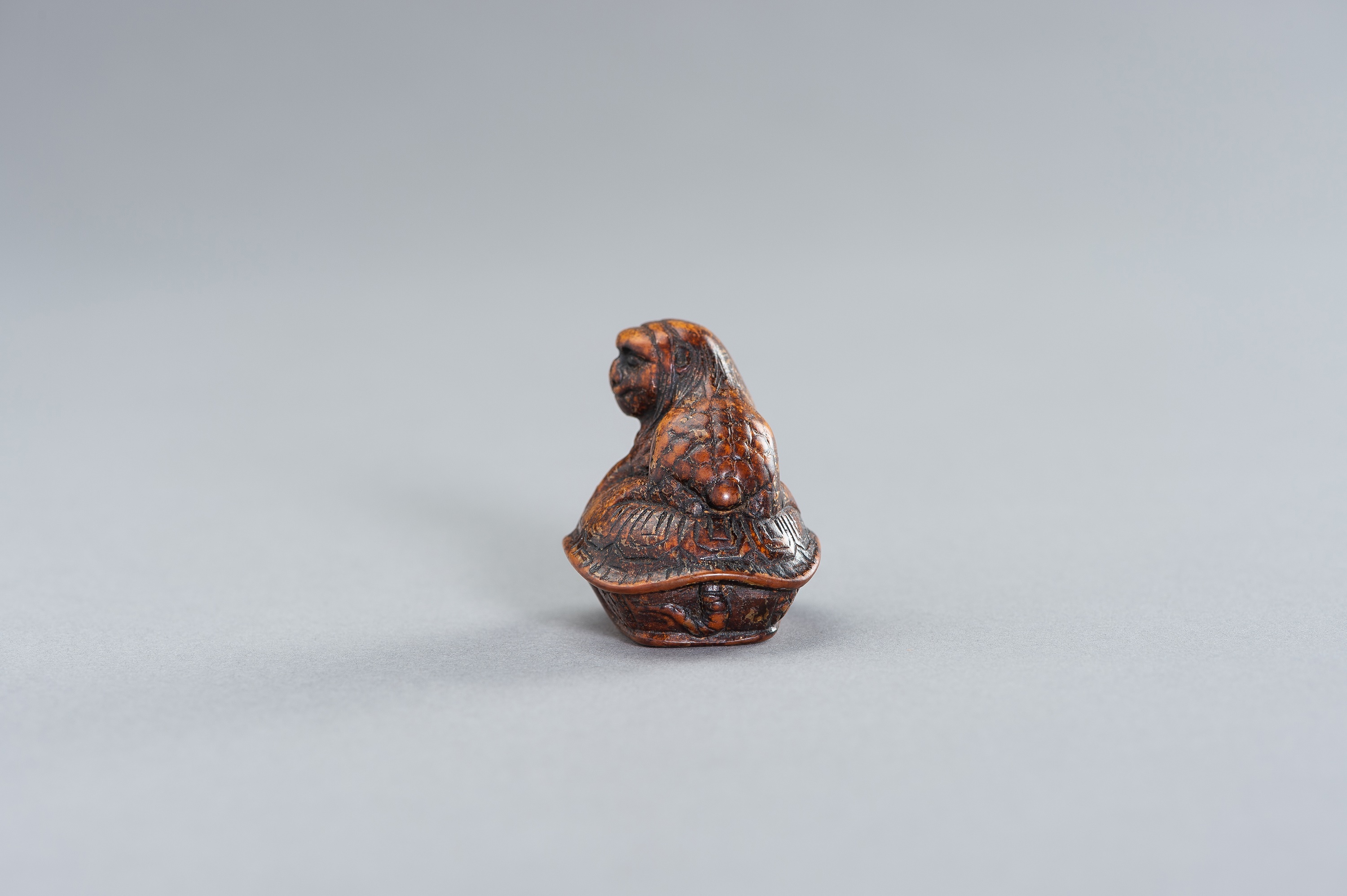 Lot 382 - A RARE WOOD NETSUKE OF A KAPPA ON A TORTOISE