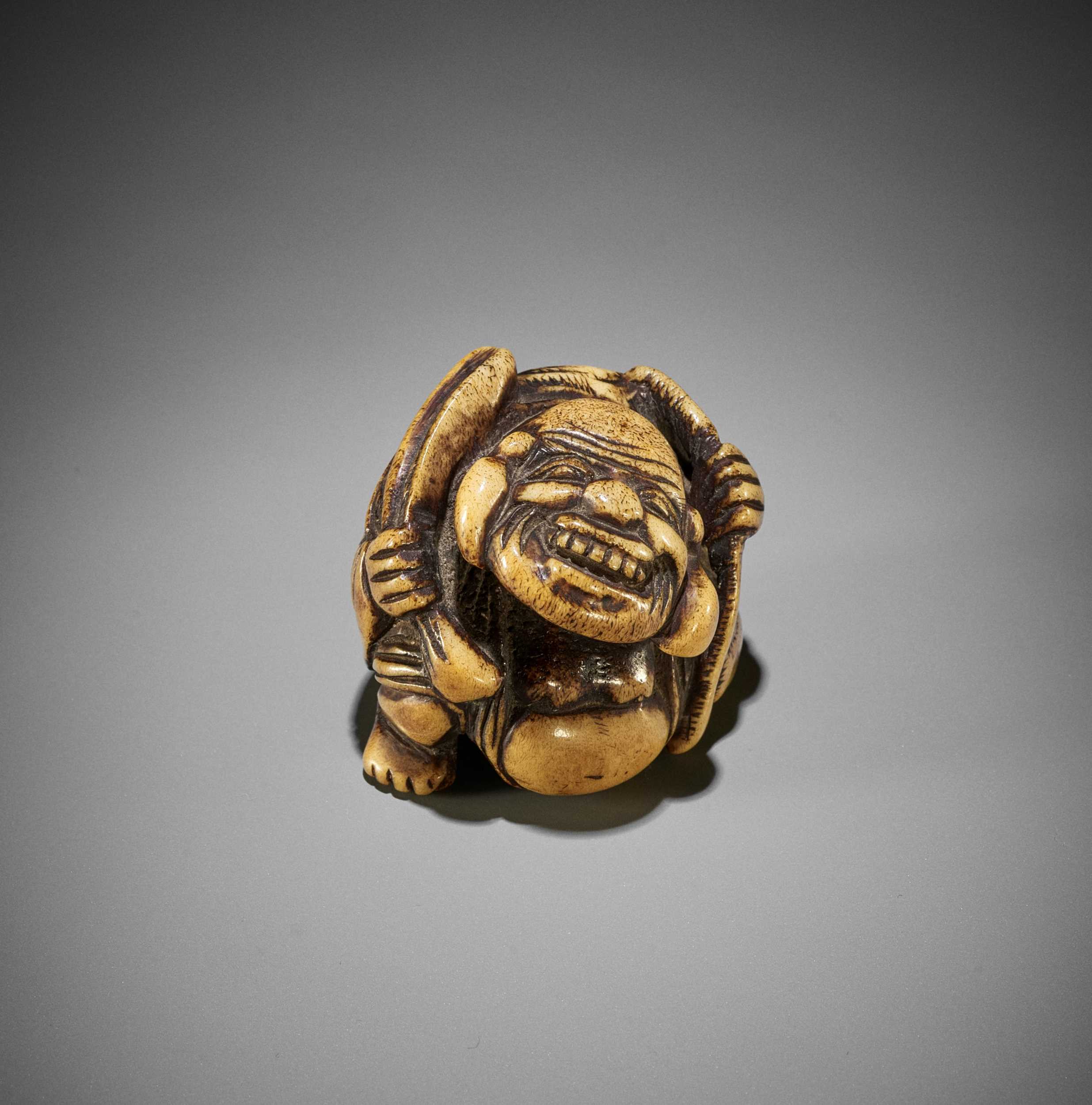 A SUPERB STAG ANTLER NETSUKE OF HOTEI