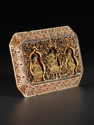 Lot 397 - A CARVED IVORY ‘BUDDHIST TRIAD’ MANUSCRIPT COVER, 17TH CENTURY