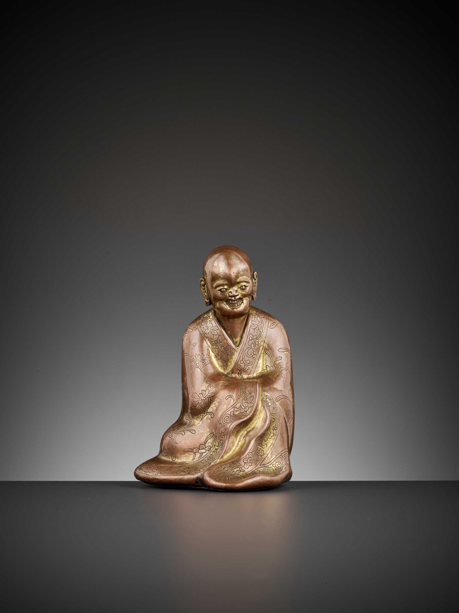 Lot 82 - A GILT COPPER ALLOY FIGURE OF A LUOHAN, 17TH CENTURY