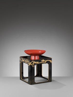Lot 154 - A RED LACQUER SAKAZUKI (SAKE CUP) DEPICTING SAMURAI ACCOUTREMENTS WITH EN-SUITE BLACK LACQUER STAND