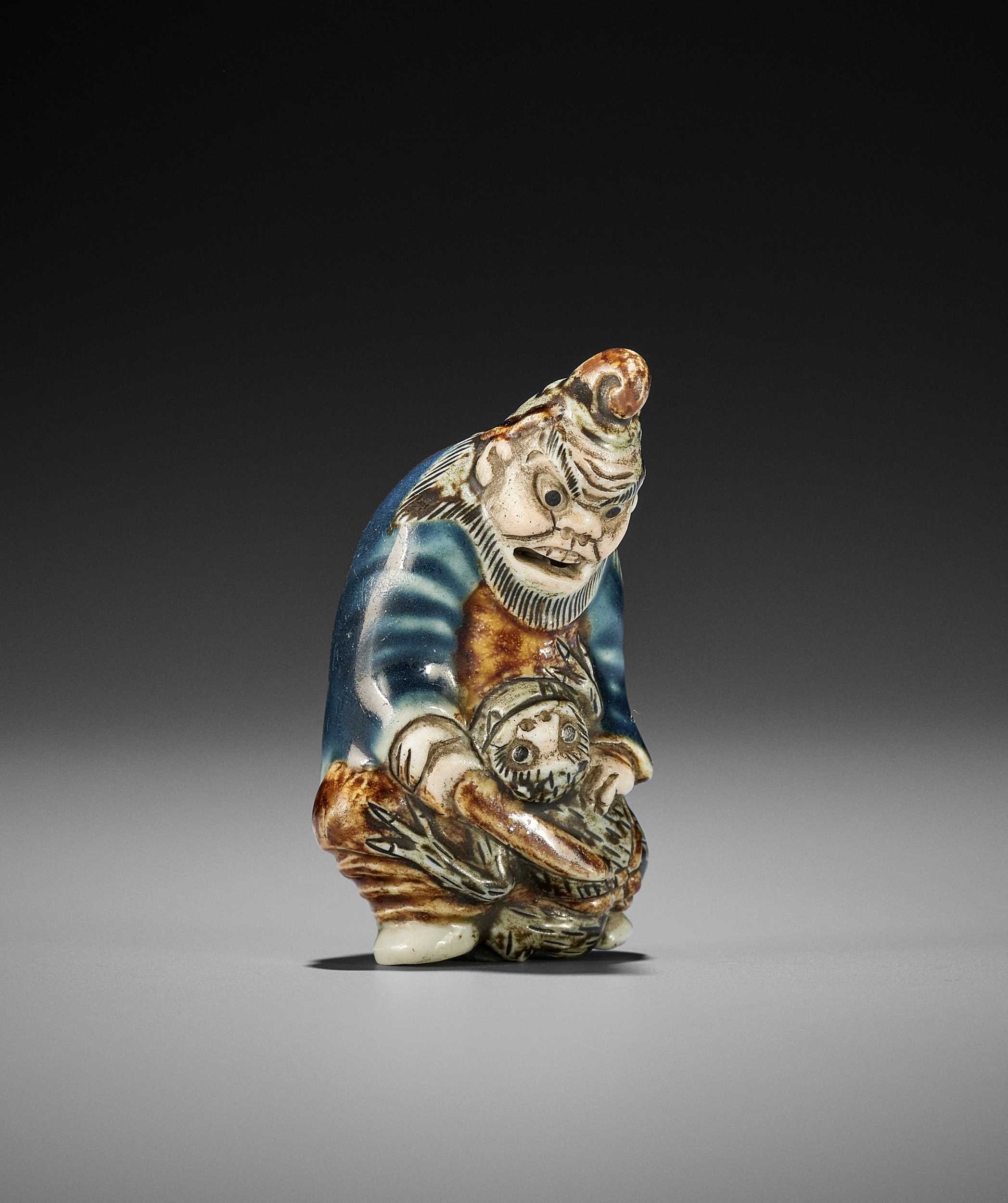 Lot 289 - A RARE HIRADO PORCELAIN NETSUKE OF SHOKI AND ONI