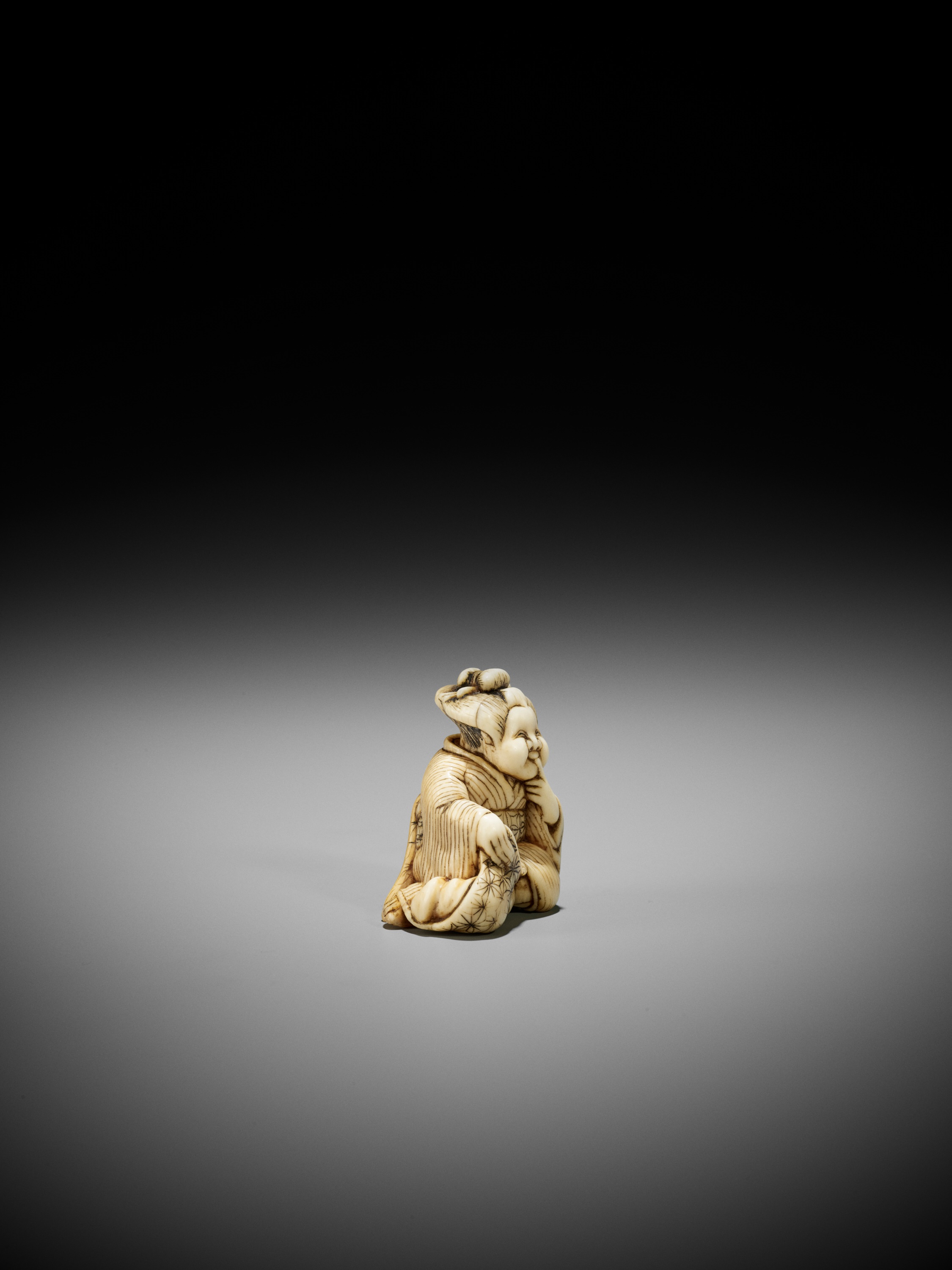 Lot 97 - A RARE IVORY SHUNGA NETSUKE OF OKAME WITH