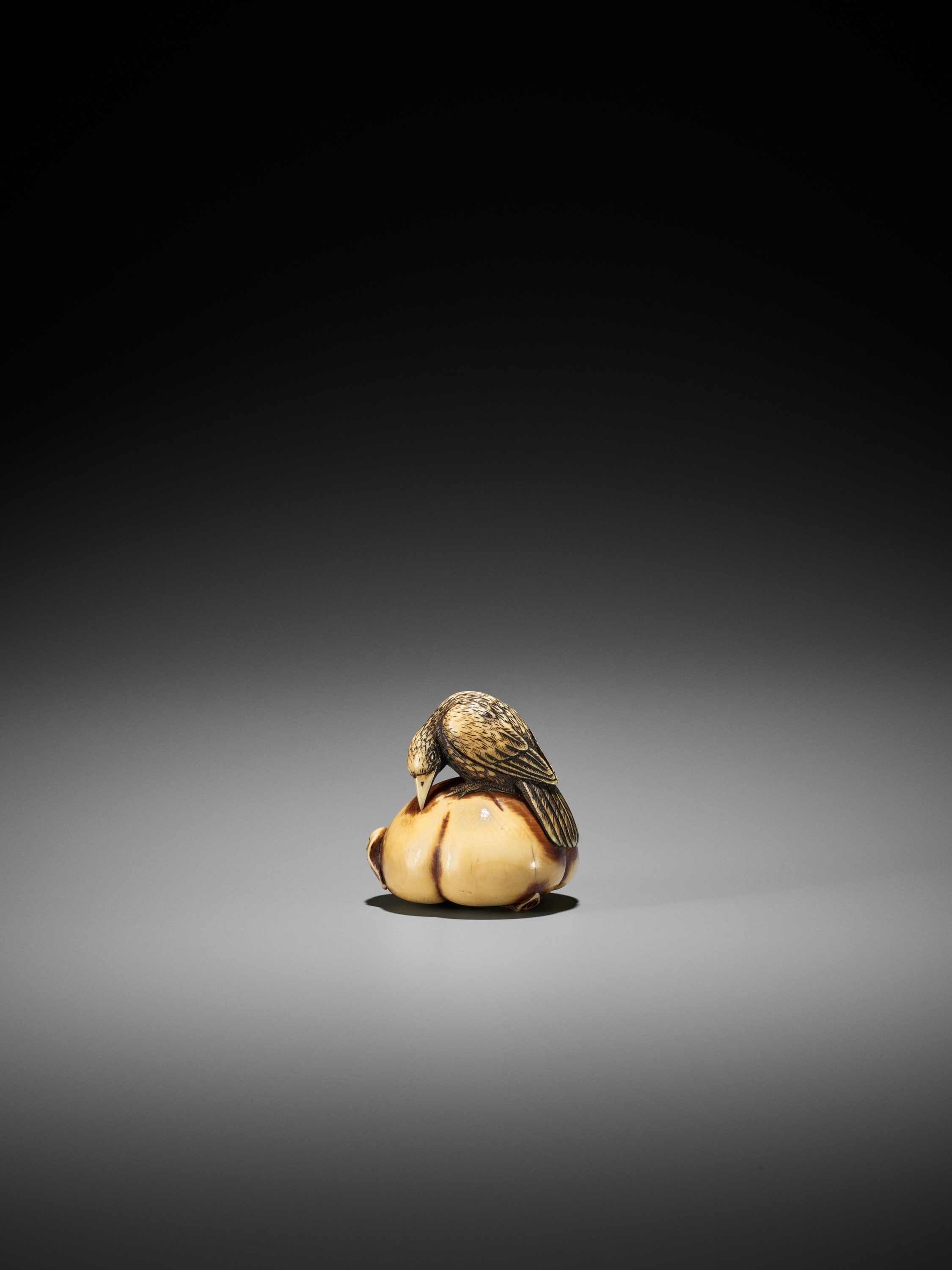 Lot 69 - ANRAKU: A FINE IVORY NETSUKE OF A CROW ON