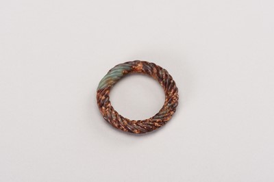 Lot 251 - A CELADON AND RUSSET JADE ROPE-TWIST RING