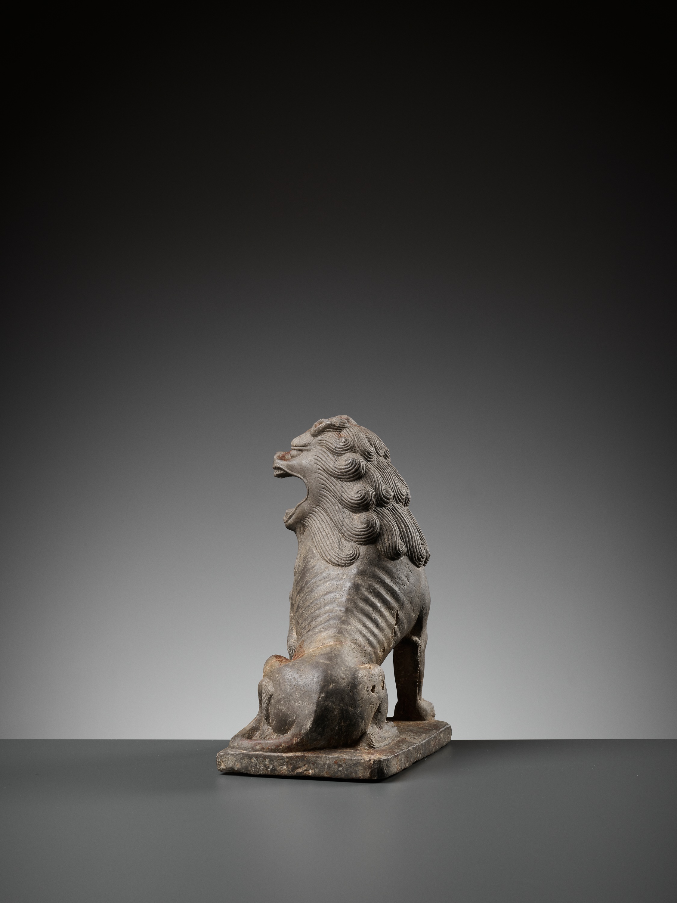 Lot 376 - A SUPERBLY CARVED LIMESTONE FIGURE OF A LION,