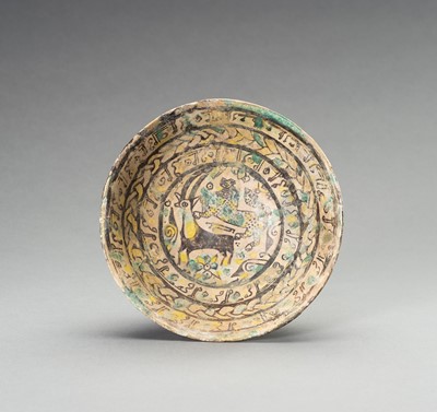 Lot 1377 - A NISHAPUR ‘IBEX AND BEAST’ POTTERY BOWL, 9TH – 10TH CENTURY