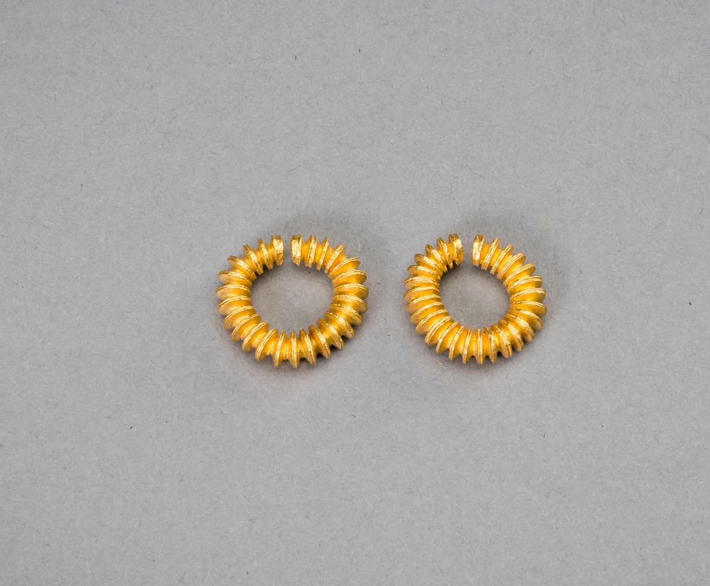 Lot 1155 - A PAIR OF EARLY CAMBODIAN RIBBED GOLD EARRINGS