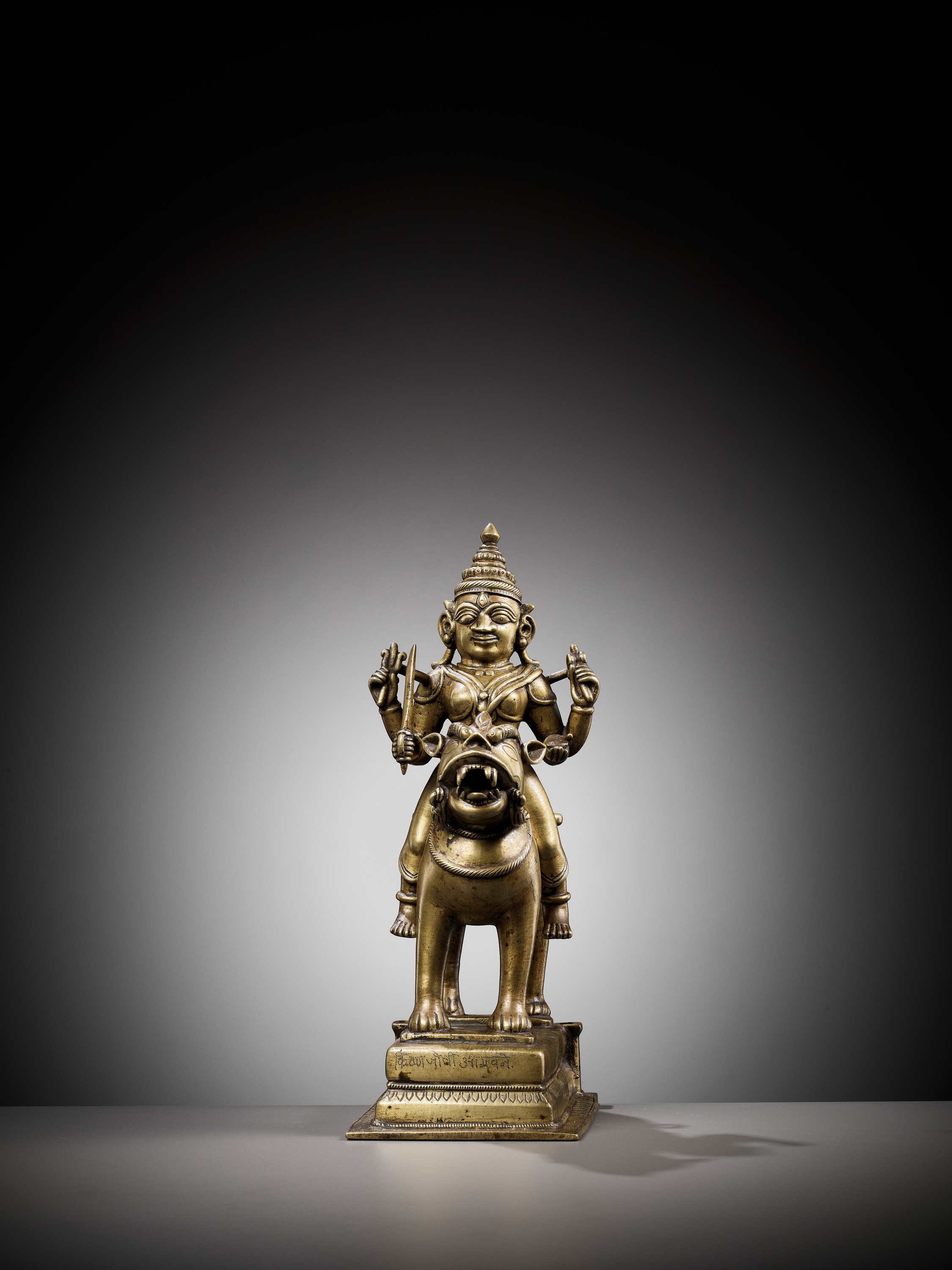 Lot 702 - A BRONZE FIGURE OF DURGA RIDING A LION,